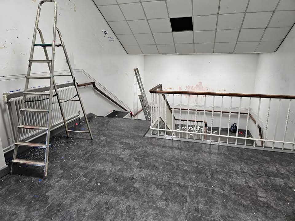 Stairwell landing in Cheshire during preparation with ladders and patched walls before painting