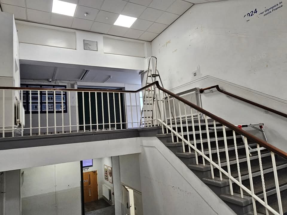 Commercial stairwell in Cheshire with marked and stained walls before decorating