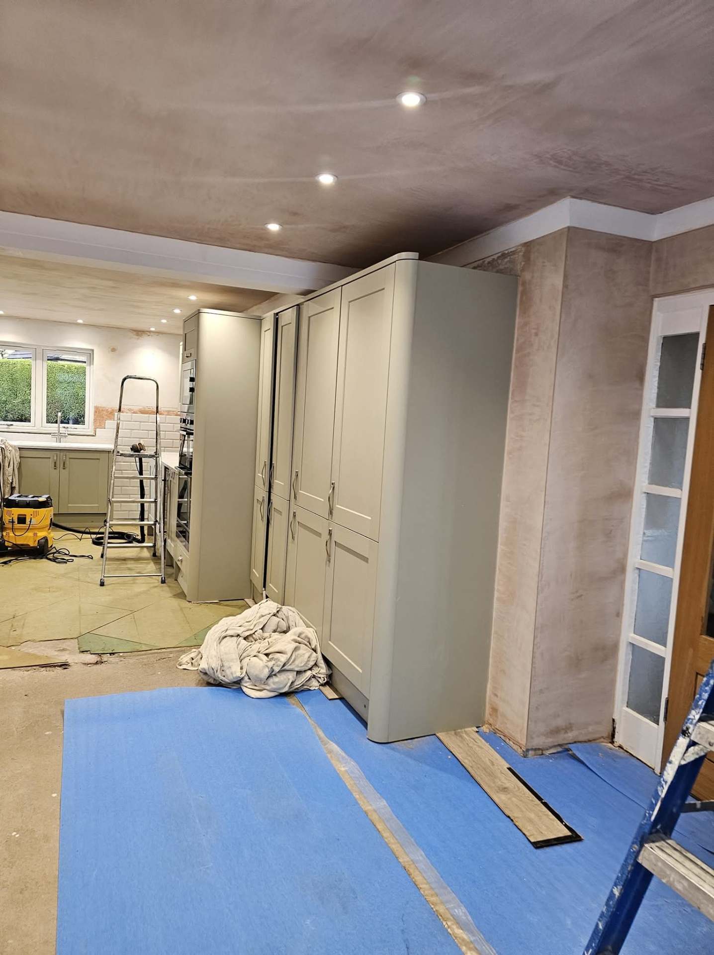 Cheshire kitchen diner mid project with bare plaster walls and dust sheets down before decorating